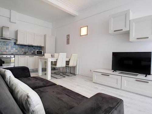 un salon blanc avec un canapé et une télévision dans l'établissement Nestor&Jeeves - BEACH ROYAL - Central, Close sea, à Nice