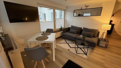 Wellness Appartement Eifelglück في Pelm: غرفة معيشة مع أريكة وطاولة
