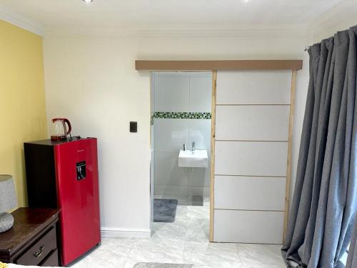 a bathroom with a red refrigerator and a sink at Boston House in Cape Town