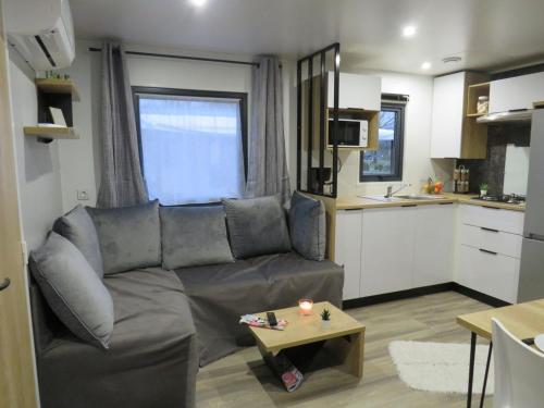 a living room with a couch and a table at Camping Les P'tites Maisons dans la Prairie in Sallertaine