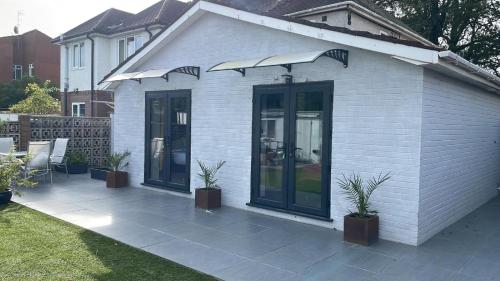 une maison blanche avec une terrasse ornée de plantes dans l'établissement Park Lane Rooms, à Abergavenny