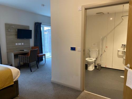 a hotel room with a bathroom with a toilet at The Lodge At Perth Racecourse in Perth