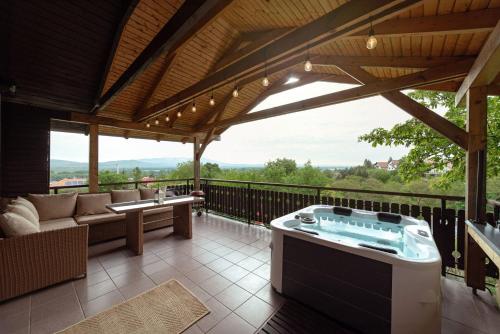 a patio with a jacuzzi tub on a deck at Bogdányi Kisház in Dunabogdány