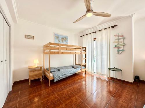 1 dormitorio con 1 cama y ventilador de techo en Baleal Happiness Surf House, en Ferrel