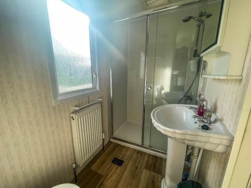 y baño con lavabo blanco y ducha. en Spacious Caravan For Hire In Hunstanton At Manor Park Holiday Park Ref 23047b, en Hunstanton