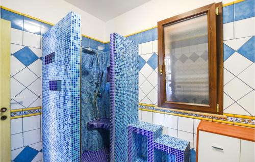 a bathroom with a shower with blue tiles at 4 Bedroom Awesome Home In Brucoli in Brucoli