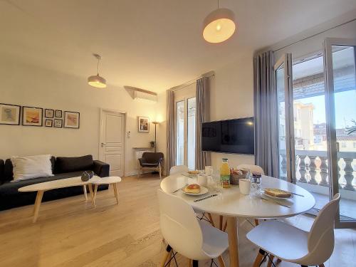 un salon avec une table et des chaises blanches dans l'établissement Nestor&Jeeves - MADAGASCAR - 3 chambres, Centre-ville, à Nice