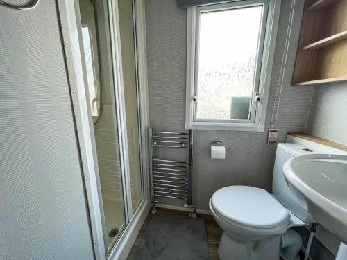 a bathroom with a toilet and a sink and a window at Lovely 8 Berth Caravan At Southview Holiday Park Near Skegness Beach Ref 33031cl in Skegness
