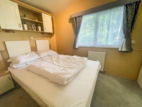 a large white bed in a room with a window at Lovely Dog Friendly Caravan At Southview Holiday Park In Skegness Ref 33053s in Skegness