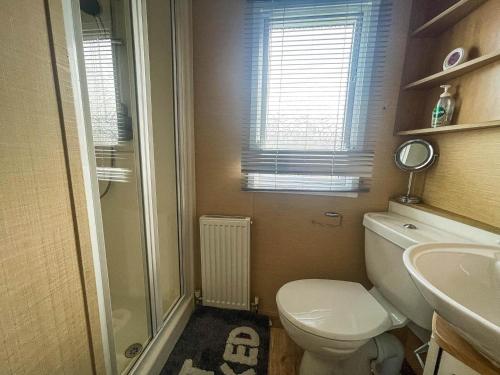 uma casa de banho com um WC, um chuveiro e um lavatório. em Lovely Dog Friendly Caravan At Southview Holiday Park In Skegness Ref 33053s em Skegness