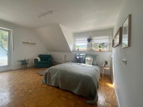1 dormitorio con 1 cama y 1 silla verde en Ferienwohnung Eifelglück, en Pelm