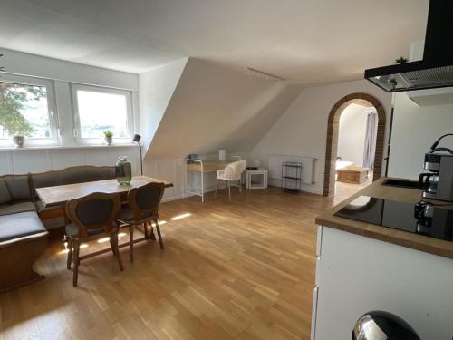 cocina y sala de estar con mesa y sillas en Ferienwohnung Eifelglück, en Pelm