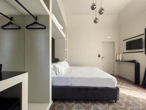 ein Schlafzimmer mit einem Bett in einem weißen Zimmer in der Unterkunft VICOLO SAN GAETANO -luxury rooms- in Catania