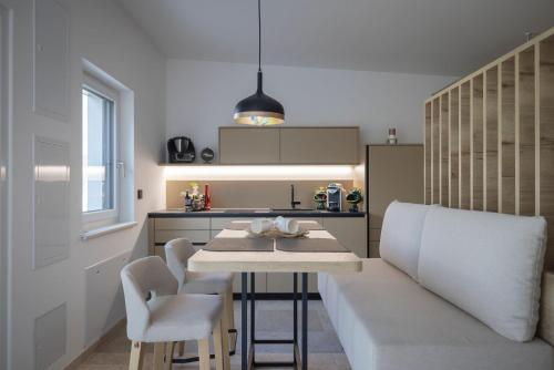 Finy Homes Stegersbach في شتيغرسباخ: مطبخ مع طاولة وكراسي في غرفة