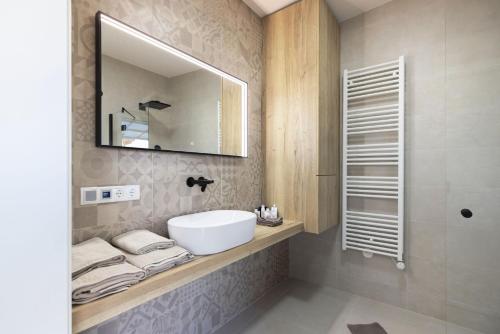 a bathroom with a sink and a mirror at Finy Homes Stegersbach in Stegersbach