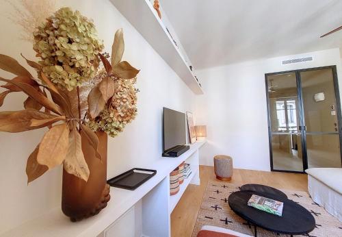- un salon avec un vase aux fleurs sur le mur dans l'établissement Nestor&Jeeves - RIVIERA - Central - Near Beach, à Nice