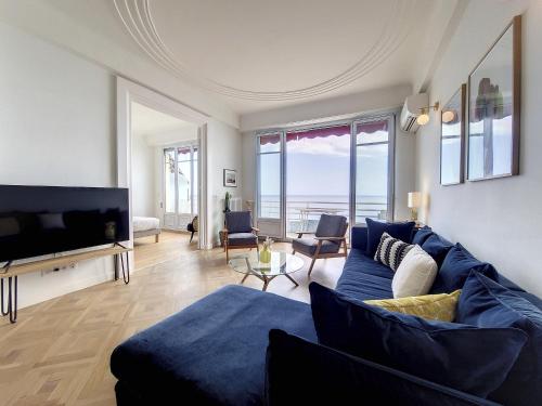 un salon avec un canapé bleu et une télévision dans l'établissement Nestor&Jeeves - MEDITERRANEE PROMENADE - Vue Mer, à Nice