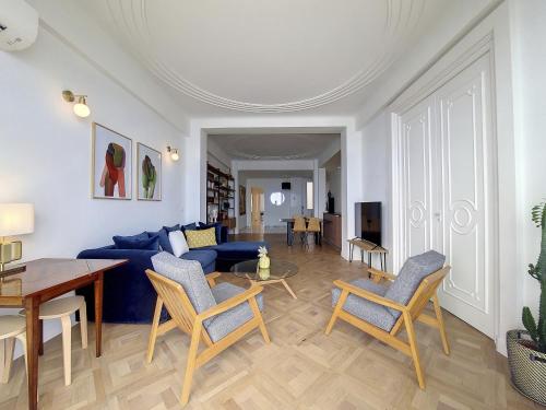 un salon avec un canapé bleu et des chaises dans l'établissement Nestor&Jeeves - MEDITERRANEE PROMENADE - Vue Mer, à Nice