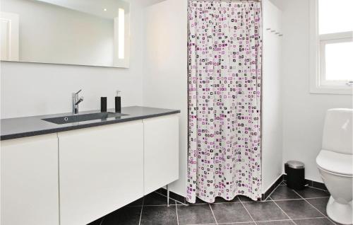 a bathroom with a sink and a shower curtain at Nice Home In Haderslev With 3 Bedrooms And Wifi in Kelstrup Strand