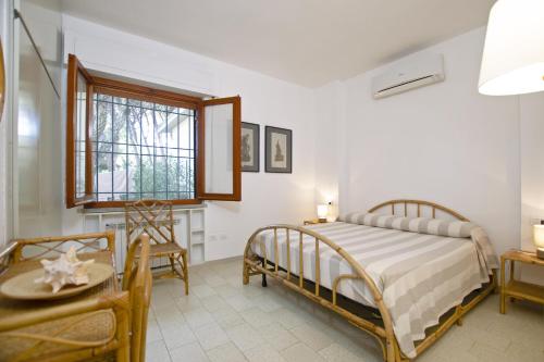 una camera con letto, tavolo e finestra di Villetta Il Pino a Punta Ala