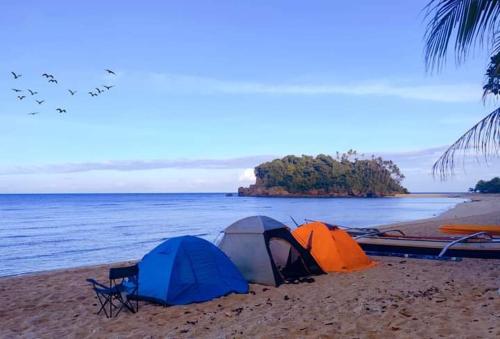 two tents on a beach near the water at KOKONUT HUT RETREAT & CAMPING SITE RENTAL in Romblon
