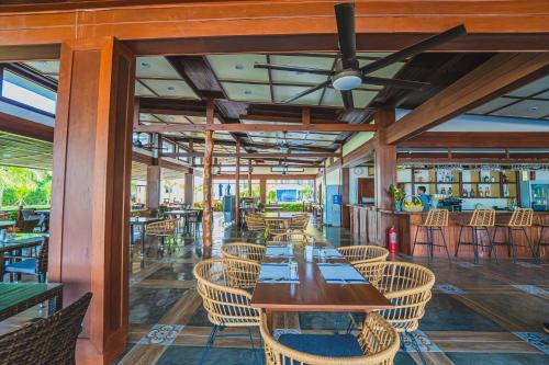 a restaurant with tables and chairs in a room at Ora Beach Resort in El Nido