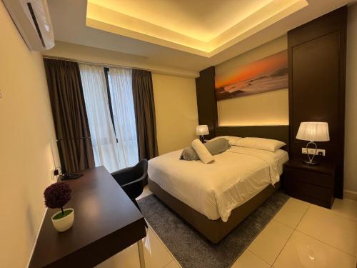 a bedroom with a bed and a table and a desk at QUINCE HOME GRAND ION DELEMEN GENTING HIGHLANDs in Genting Highlands