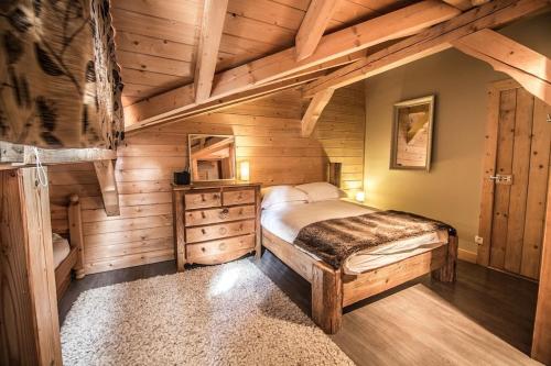 a bedroom with a bed in a wooden cabin at Chalet Pomet in Morillon