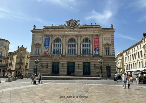 a large building with people walking in front of it at Kyriad Hotel Montpellier Centre Antigone in Montpellier