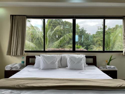 1 dormitorio con 1 cama y ventana grande en Surve Natures Resort - Chiplun, en Chiplun