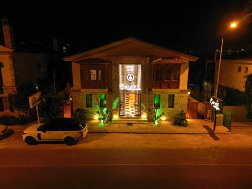 a house with a car parked in front of it at night at Şerefe Hotel Alaçatı in Alaçatı