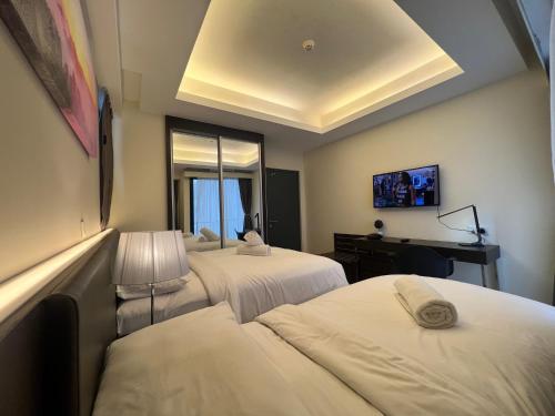 a hotel room with two beds and a desk at QUINCE HOME GRAND ION DELEMEN GENTING HIGHLANDs in Genting Highlands