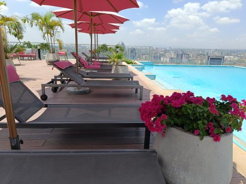 - une piscine avec des chaises et des parasols dans un bâtiment dans l'établissement Skynest Residences by Lisa's Paradise C, à Nairobi