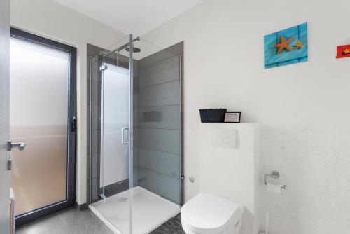 a bathroom with a toilet and a glass shower at Libra in Nova Vas