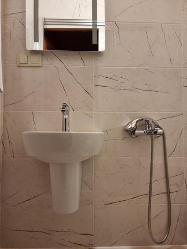 a white sink in a bathroom with marble walls at HaciBayramApart in Istanbul