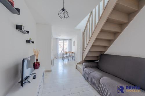 sala de estar con sofá y escaleras en Le Joli - Parking - Near Perpignan, en Saleilles