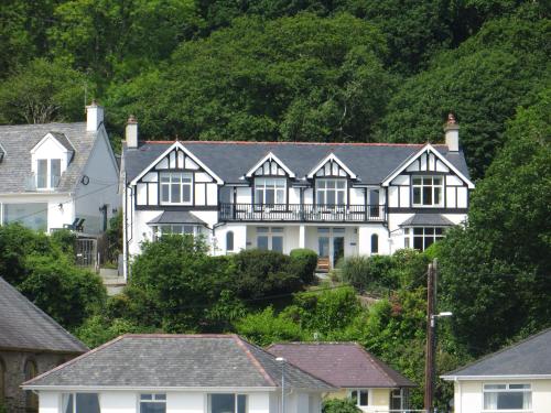 a large white house on the side of a hill at Bryn Gwyn & Tegfryn a Pair of Cottages Sea & Mountain Views Borth y Gest in Porthmadog
