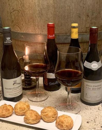 a table with three bottles of wine and three glasses at Nouveau - Maison confortable à Gevrey-Chambertin in Gevrey-Chambertin