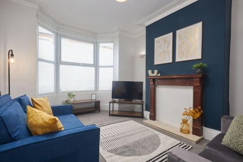 a living room with a blue couch and a tv at Comfortable Teesside House With On Street Parking in Stockton-on-Tees