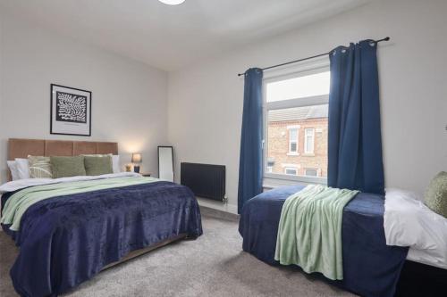 a bedroom with two beds and a large window at Comfortable Teesside House With On Street Parking in Stockton-on-Tees