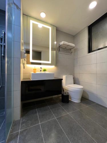a bathroom with a sink and a toilet and a mirror at QUINCE HOME GRAND ION DELEMEN GENTING HIGHLANDs in Genting Highlands