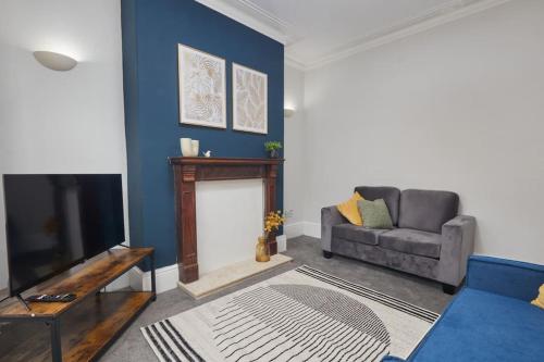 a living room with a couch and a fireplace at Comfortable Teesside House With On Street Parking in Stockton-on-Tees
