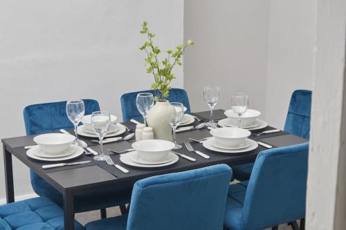 a black table with blue chairs and a blue dining room at Comfortable Teesside House With On Street Parking in Stockton-on-Tees