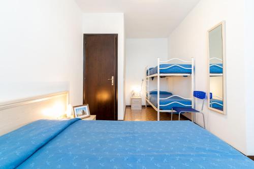 a bedroom with a blue bed and two bunk beds at Tivoli in Bibione