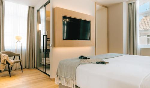 a hotel room with a bed and a tv on the wall at Pestana Rua Augusta Lisboa in Lisbon