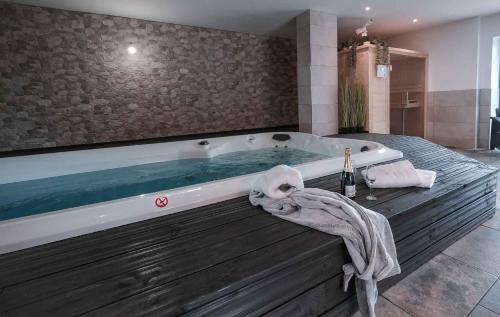 ein großes Bad mit einer Badewanne und einem Handtuch darauf in der Unterkunft Les Bastides de Roquemaure 