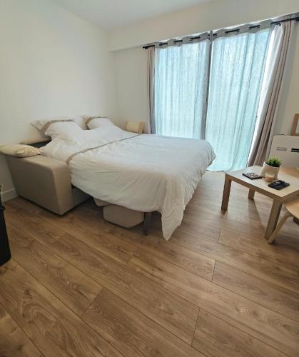 sypialnia z łóżkiem i drewnianą podłogą w obiekcie Studio Saint-Laurent-Du-Var 50m de la mer w mieście Saint-Laurent-du-Var
