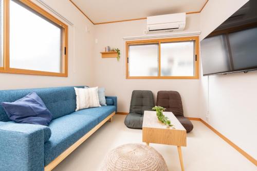 a living room with a blue couch and chairs at YUKIMARU in in Tokyo
