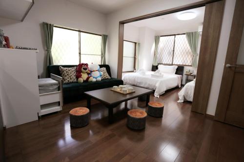 a living room with a bed and a couch and a table at Kita 2 Storey Homestay in Tokyo