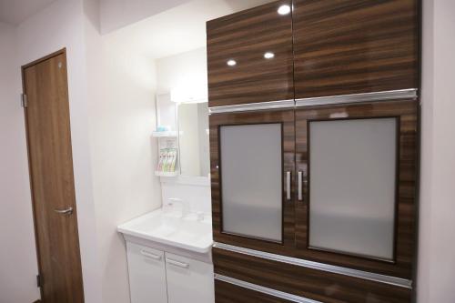 y baño con lavabo y espejo. en Kita 2 Storey Homestay, en Tokio